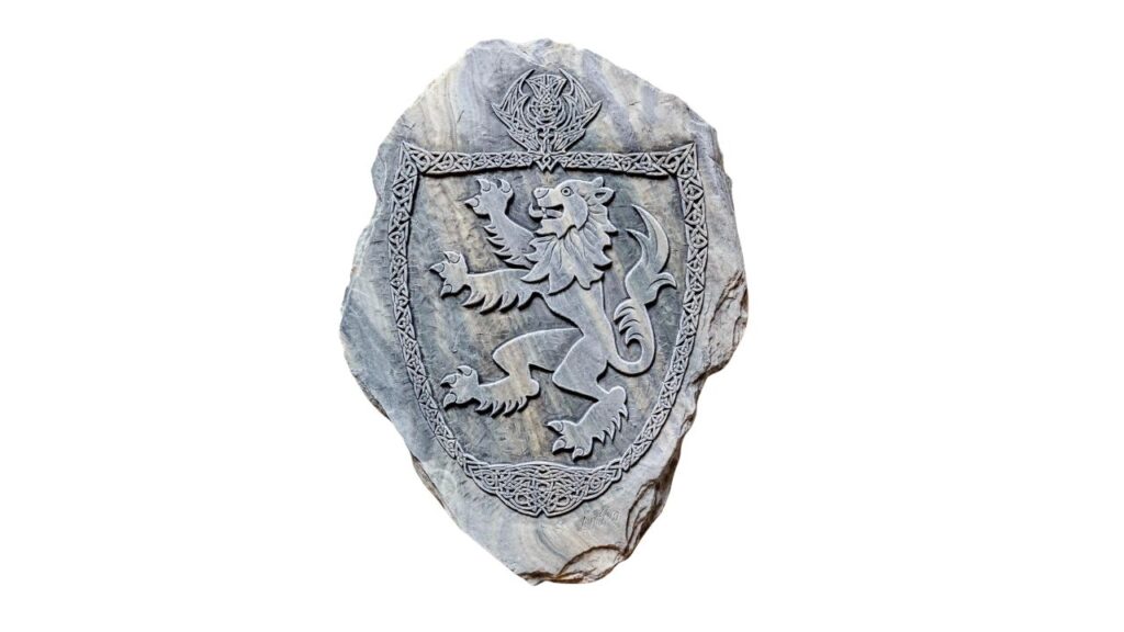 Faded lion rampant carved in stone on an old Scottish castle wall.